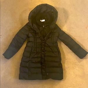 Black down winter jacket, mid thigh length.